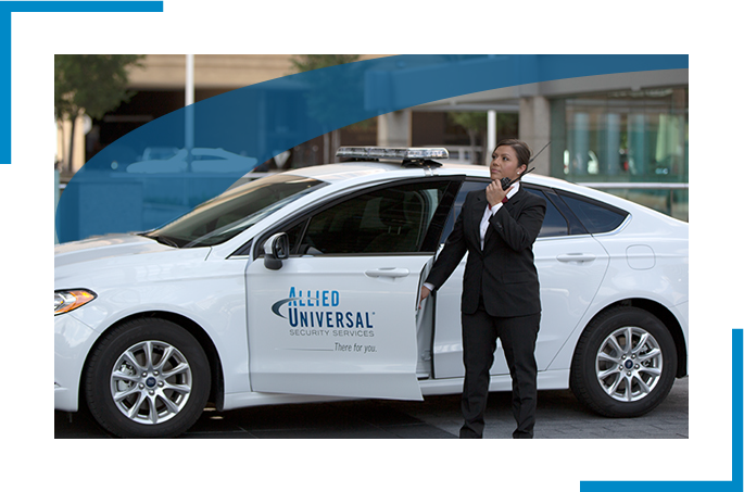 Security professional in a suite holding the door of a car